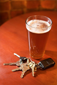 drunk driving: color photo of glass of beer and car keys on brown table