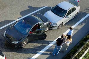 driverless cars: photo of two men and a woman looking at two cars involved in crash