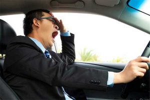 Photo of driver yawning behind the wheel of car