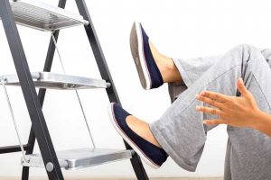 Photo of woman's legs and hand as she falls from ladder, one of the most dangerous items found in most homes