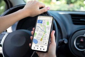 driver holding smartphone open to navigation app