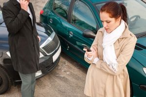 Motor vehicle accident victims reporting crash and exchanging information at accident scene