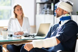 Traffic accident victim in bandages discusses case with attorney