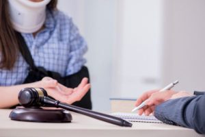Personal injury lawsuit mistakes to avoid; woman in neck brace discussing details of accident while another person takes notes